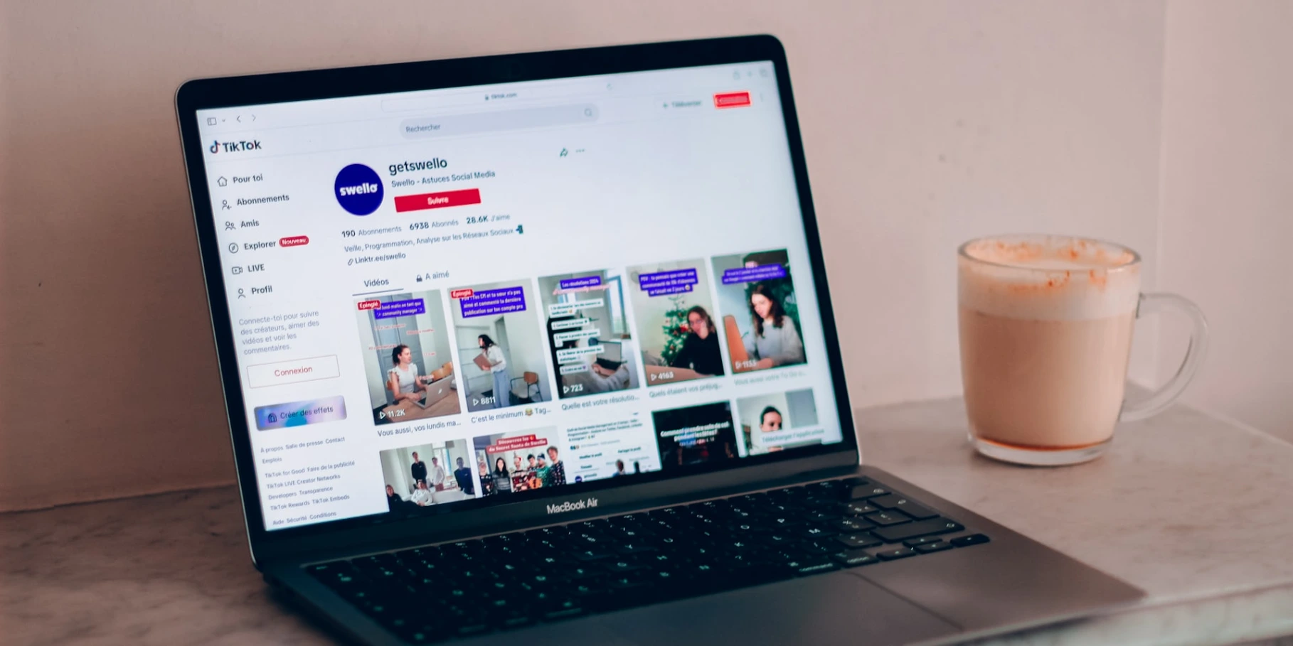 a laptop computer sitting on top of a table next to a cup of coffee